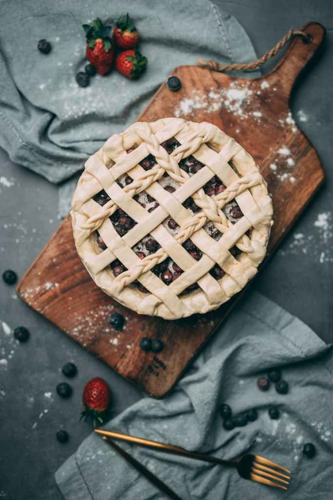 photo of berry pie on top of wooden chopping board